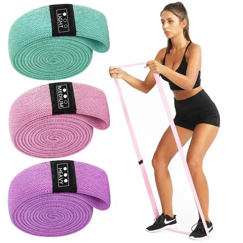woman training with a pink fabric long resistance band under her feet